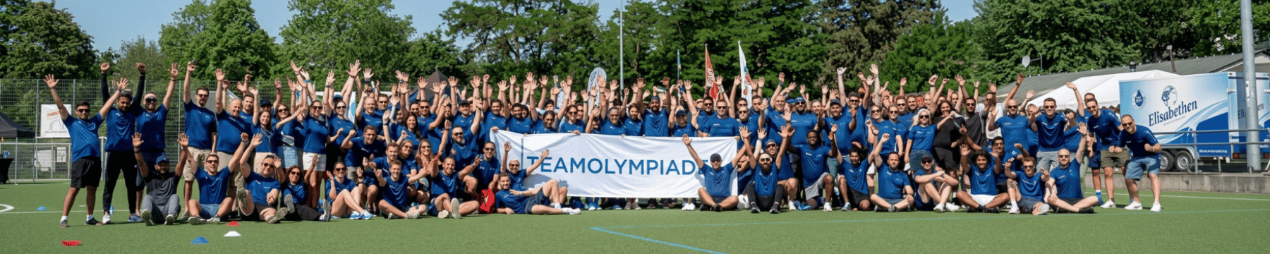 Team jubelt und hält Teamolympiade Flagge hoch