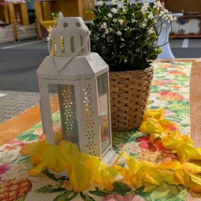 Tisch mit sommerlicher Deko und Pfalnze, Teelichthalter und Blumenkette