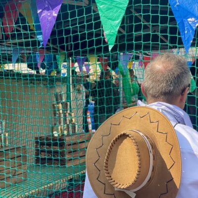 Mann mit Cowboyhut vor Dosenwerfen