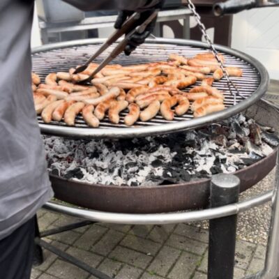 Koch dreht Würstchen bei Grillfest