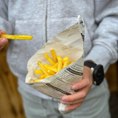 Kind hält bei Grillfest Pommes Frites in der Hand