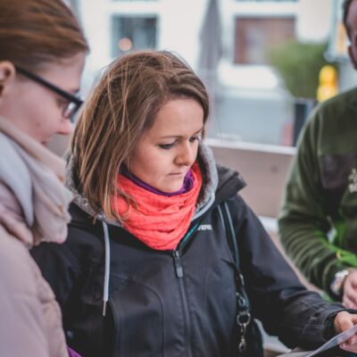 Zwei Teilnehmerinnen einer Schnitzeljagd schauen sich Roadbook an