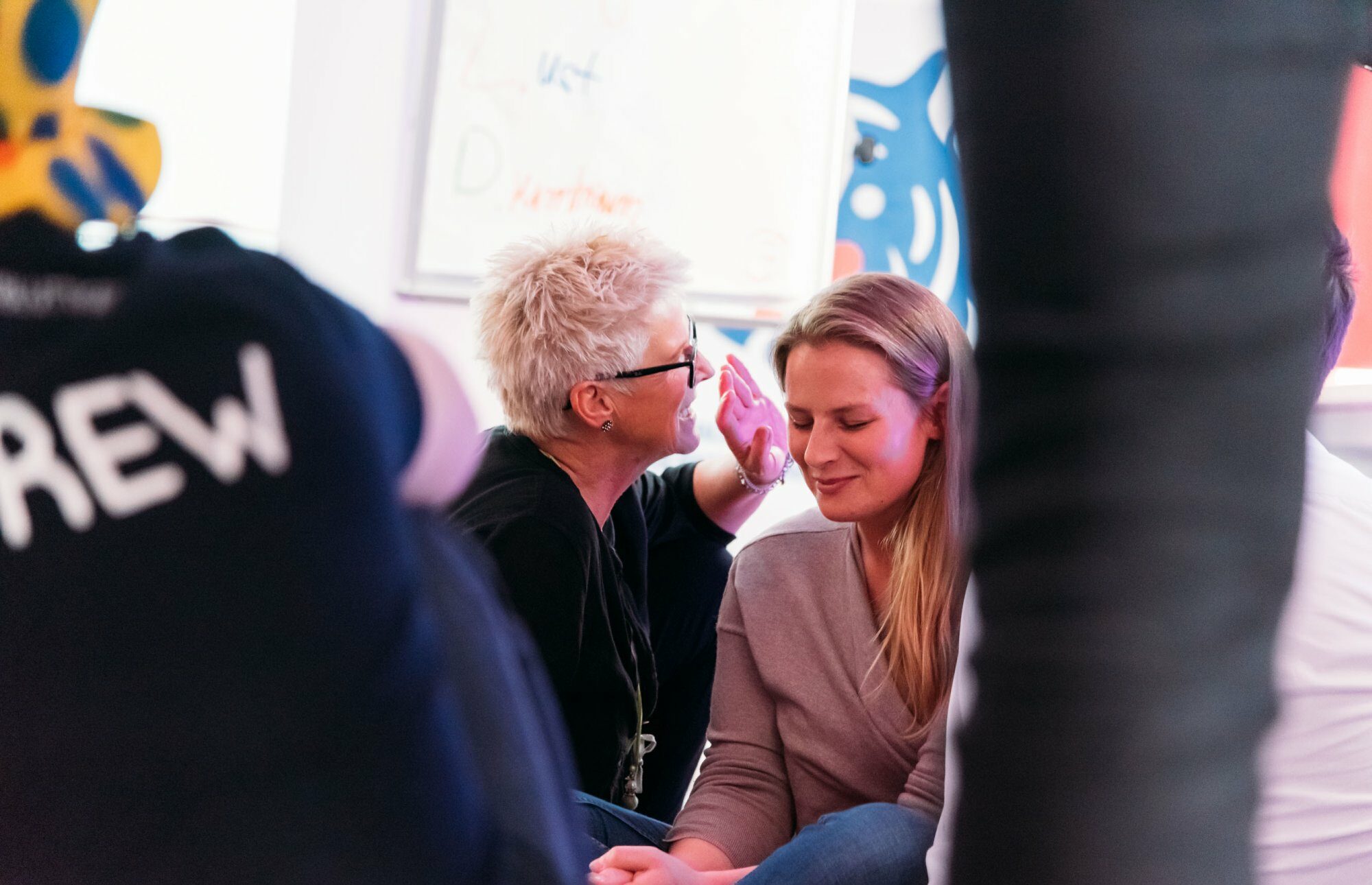 Coachin, die einer Frau etwas ins Ohr flüstert