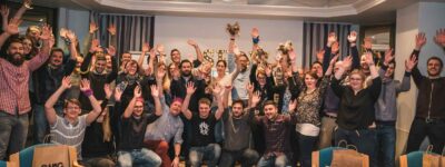 Gruppe jubelt bei Quizshow Firmenfeier in Kamera