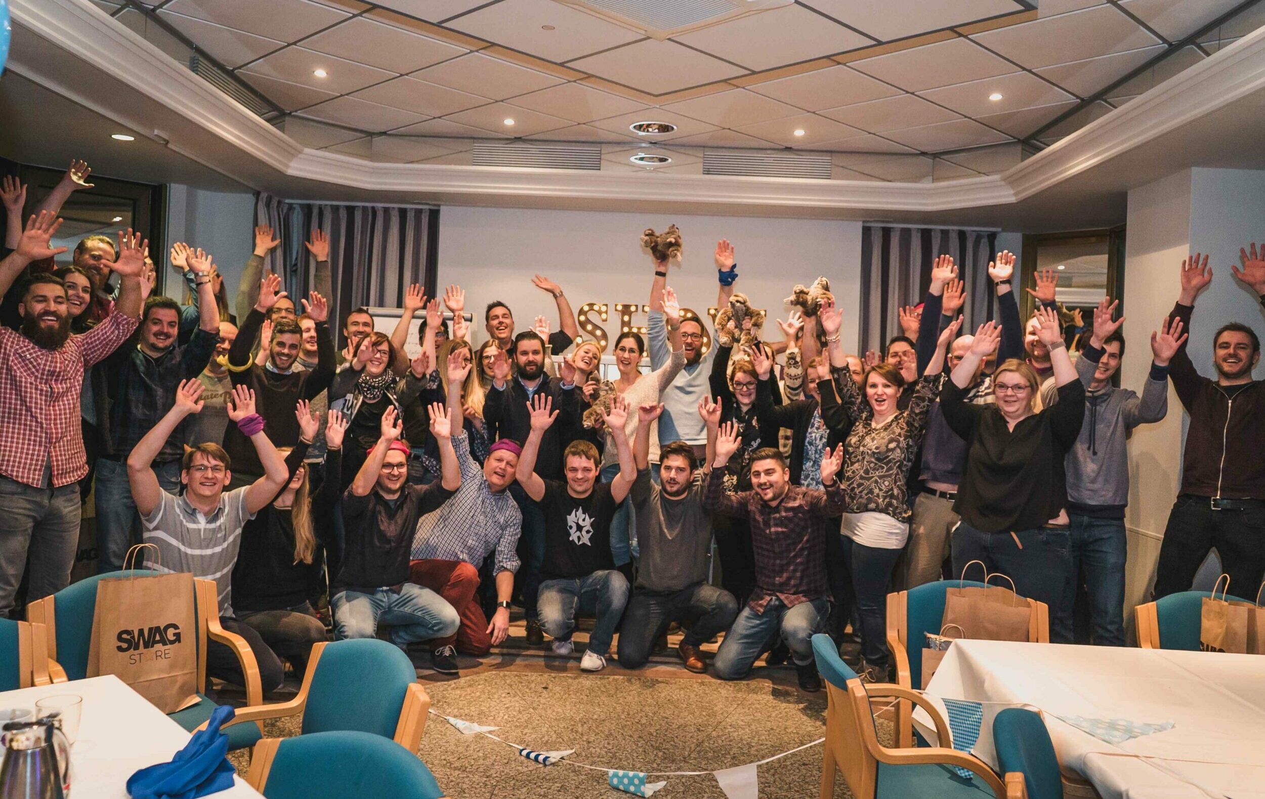 Gruppe jubelt bei Quizshow Firmenfeier in Kamera