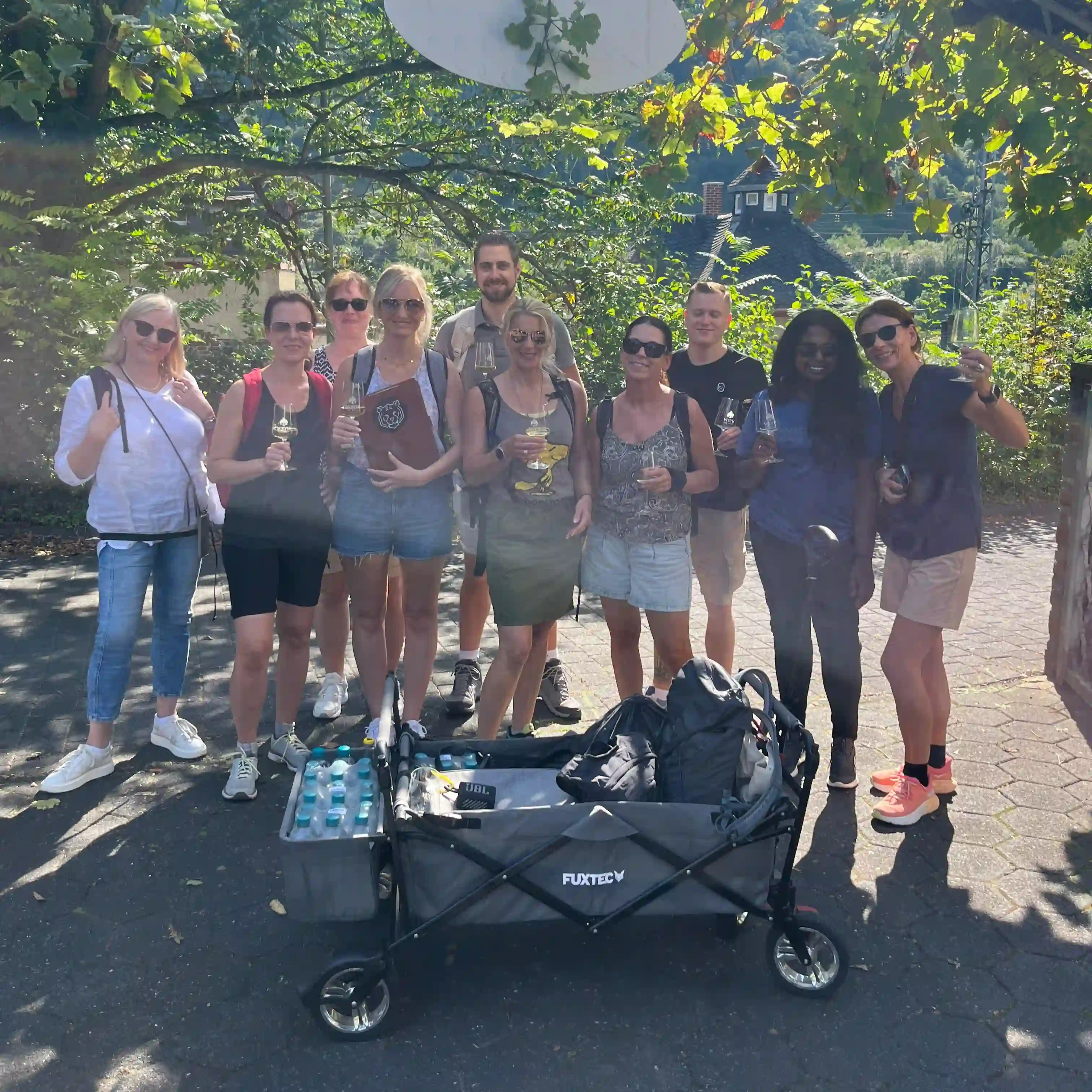 Gruppenfoto mit Weingläsern und Bollerwagen am Weingut