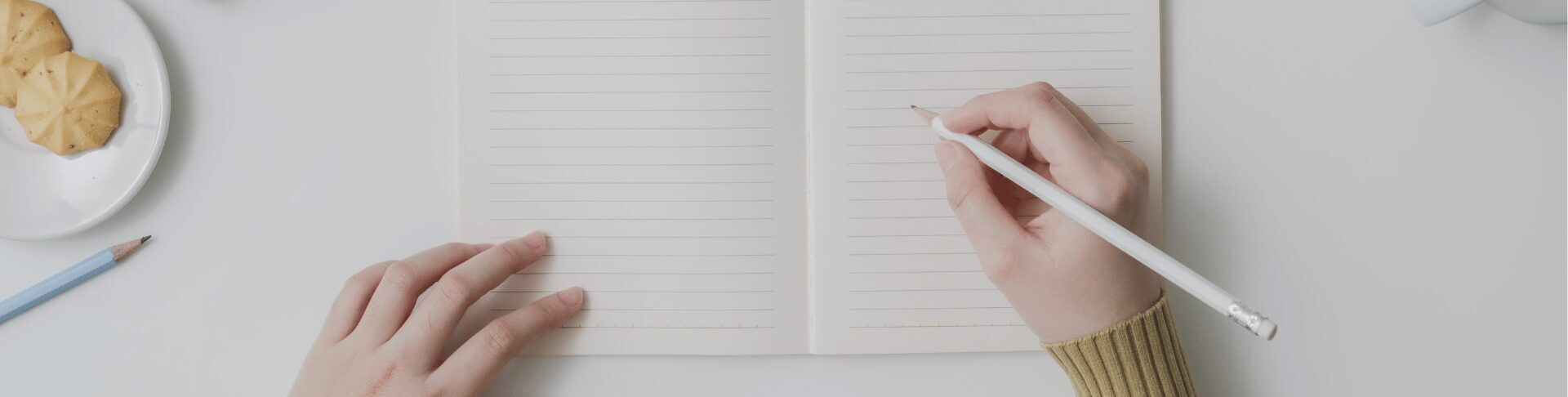 Frau schreibt etwas in ein leeres Notizbuch