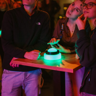 Teilnehmerin drückt auf Buzzer während Quiz Night