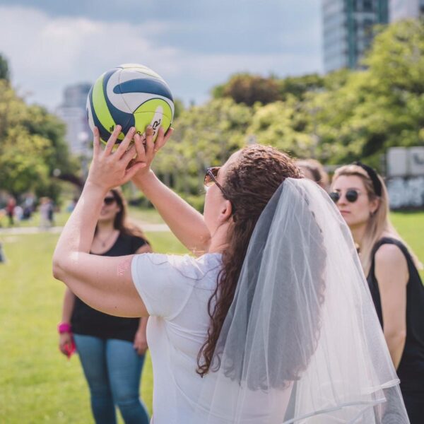 Braut wirft Ball, andere schauen zu