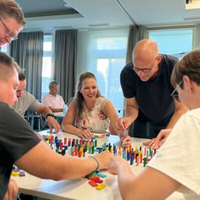 4 Männer und eine Frau spielen Domino